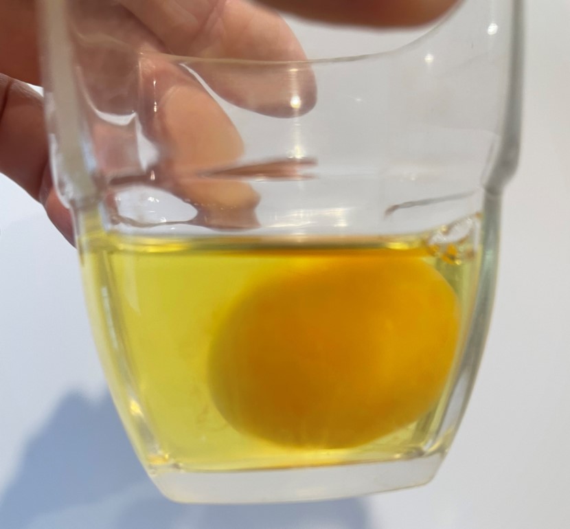 jaune qui flotte dans le blanc dans un verre