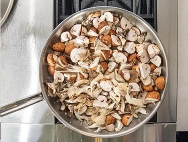 Grande quantité de champignons dans une poêle.